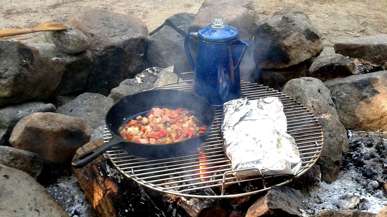 Campfire cooking in an outdoor glamping setting